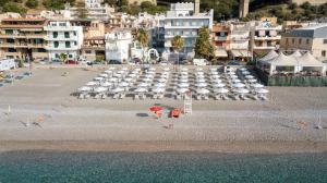 a beach with chairs and umbrellas on the beach at Albatros Beach Hotel in Letojanni