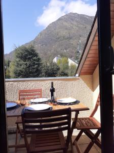 a wooden table with two chairs and a view of a mountain at Saint Lary Ski, rando, thermes, balades et repos ! in Saint-Lary-Soulan