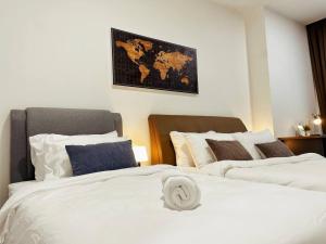 Duas camas num quarto com um mapa na parede em Arcoris Mont Kiara 1~6 Pax Contemporary Living Netflix em Kuala Lumpur