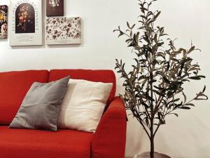 um sofá vermelho com uma almofada e uma árvore em Arcoris Mont Kiara 1~6 Pax Contemporary Living Netflix em Kuala Lumpur