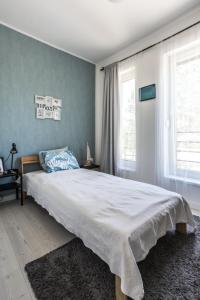 a bedroom with a large bed and two windows at Dream Summer House Fonyód in Fonyód