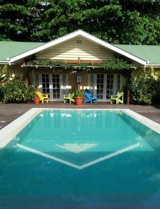 a blue swimming pool in front of a house at Residence Praslinoise in Grand'Anse Praslin