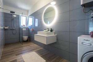 ein Bad mit einem Waschbecken und einem Spiegel in der Unterkunft Dream Summer House Fonyód in Fonyód