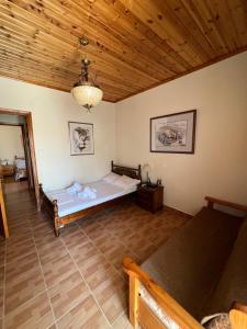 a bedroom with a bed and a wooden ceiling at Tonia’s & Chris House in Kalliópi