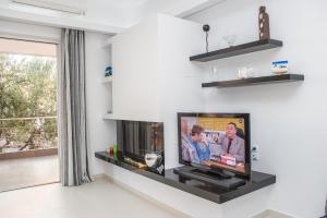 a living room with a flat screen tv on a wall at Nina's Villa, Cosy Seaview Retreat in Verga Kalamata