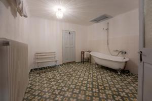 a bathroom with a tub and a tiled floor at Casa La Strada in Sighişoara