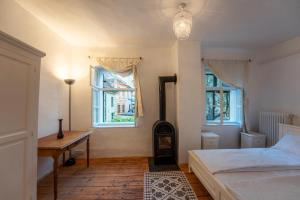 a bedroom with a bed and a desk and two windows at Casa La Strada in Sighişoara