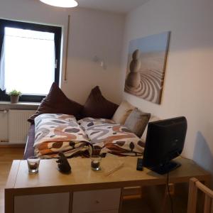 uma sala de estar com um sofá e uma secretária com um computador em Apartment Stasch em Erlangen