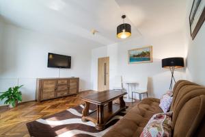 a living room with a couch and a table at Hotel Sasanka in Tatranská Lomnica