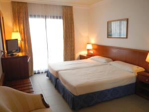 a hotel room with a bed and a television at Hostal Vila del Mar in Lloret de Mar