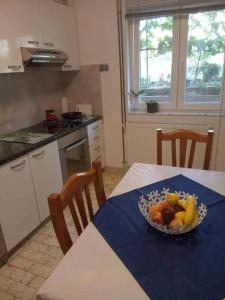 un plato de fruta en una mesa de la cocina en Owl NEST, Homestay Rooms, en Knin
