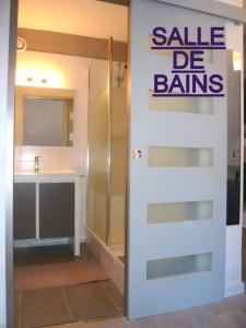 uma casa de banho com uma porta branca com uma venda ser sinal de ganhos em APPARTEMENT CLAIR ET MODERNE AU CALME em Barèges