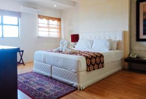 - une chambre avec un grand lit blanc dans l'établissement RedDoorz @ Joyce Palace Antique, à San Jose de Buenavista