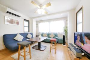 a living room with a blue couch and a table at 押上ハウス in Tokyo