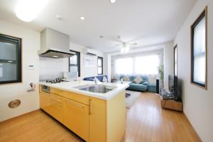 a kitchen with a sink and a living room at 押上ハウス in Tokyo