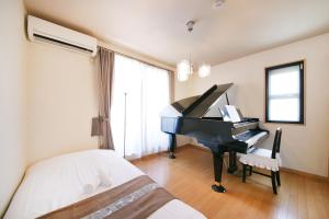 a bedroom with a piano and a bed at 押上ハウス in Tokyo