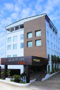 un edificio con una señal delante de él en Quality Inn VIHA, en Kumbakonam