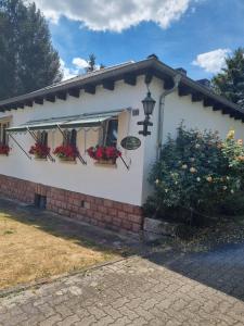 une maison blanche avec des boîtes de fleurs sur elle dans l'établissement B&B DRESSINGS TRAUMGARTEN, à Kaiserslautern