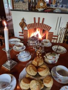 uma mesa com pratos e uma lareira num quarto em B&B DRESSINGS TRAUMGARTEN em Kaiserslautern