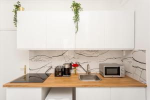 encimera de cocina con microondas y fregadero en Cosy 2 bedrooms apartment with bathrooms - Louvre en París