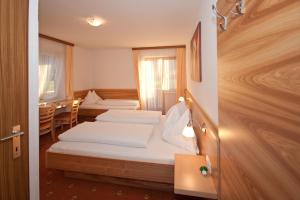 een hotelkamer met 2 bedden en een tafel bij Bed & Breakfast Plattenhof in Telfs