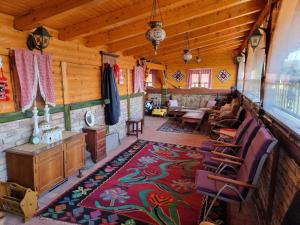 - un salon dans une cabane en rondins dotée d'un tapis dans l'établissement Comfort A&M, à Sarajevo