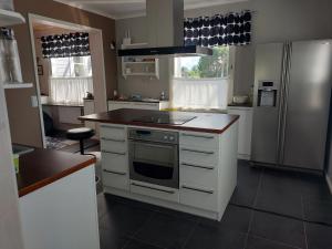 a kitchen with white cabinets and a stainless steel refrigerator at Villa Orismala 