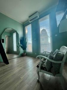 um quarto azul com uma cadeira e um espelho em Les Terrasses, charme et authenticité en Hyper Centre de TOULON, Idéal pour un séjour romantique ou une escapade urbaine em Toulon