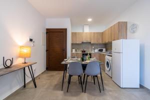 a kitchen with a table and chairs and a refrigerator at Olive 2-Bedroom Apartment in Larnaca in Larnaka