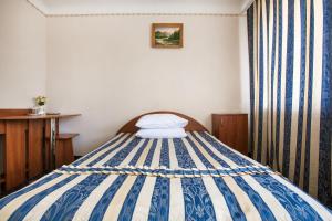 Un pequeño dormitorio con una cama azul y blanca en Bukovyna Hotel, en Chernivtsi