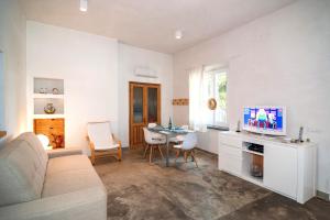 a living room with a couch and a table with a tv at CASA DELEDDA in Budoni