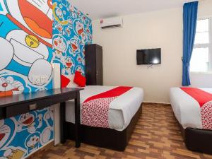 a hotel room with two beds and a tv at Gold City Hotel in Melaka