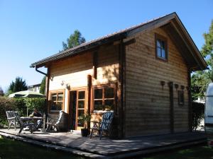 Cabaña de madera con mesa y sillas en una terraza en Ferienblockhaus en Mattsee