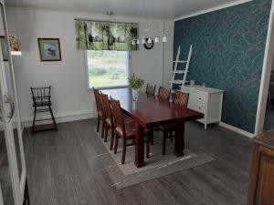 a dining room with a wooden table and chairs at Villa Orismala in Isokyrö +18 photos