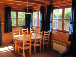 a dining room with a table and chairs and windows at Ferienblockhaus in Mattsee