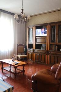 sala de estar con sofá, mesa y TV en Il piccolo casale 1950, en Fabriano