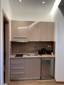a kitchen with white cabinets and a sink at 11 Luxury Apartments.. in Metsovo