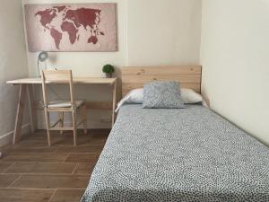 een slaapkamer met een bed en een bureau en een tafel en stoel bij Rural Confort Cataluña-Sur in Campredó