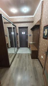pasillo con 2 puertas en una habitación con suelo de madera en Orange apartment with panoramic view, en Bishkek