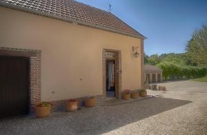 a building with potted plants in front of a door at Le Logis Du Regisseur in Charny