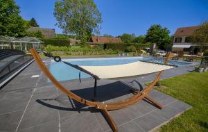 a hammock sitting in front of a swimming pool at Le Logis Du Regisseur in Charny +11 photos