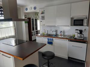 a kitchen with white cabinets and a black counter top at Villa Orismala in Isokyrö