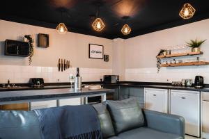 a kitchen with a couch in front of a counter at The Venue Serviced Apartments in Huddersfield