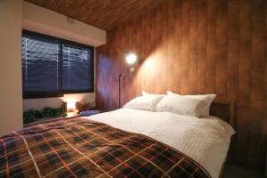 Schlafzimmer mit einem Bett und einem Fenster in der Unterkunft SERENAR Minami 13 Jo 8F in Sapporo