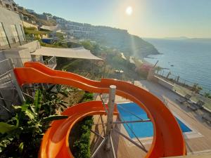 an orange slide on the side of a building next to the ocean at Single Room at Adabuku Seba Solemar Holiday Site -Luxury Beach Utilities Included in Bogazici