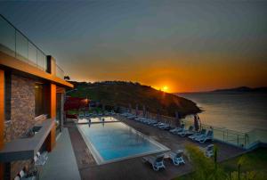 a hotel with a swimming pool and the ocean at sunset at Single Room at Adabuku Seba Solemar Holiday Site -Luxury Beach Utilities Included in Bogazici