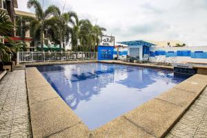 a large swimming pool with blue water in a city at Super OYO Capital O 786 Kwe Hotel And Resort in Angeles