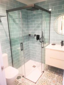 a bathroom with a glass shower with a toilet at SUITE PLAYA GIJON CENTRO, apartamento nuevo, 5 huéspedes VUT-3622-AS in Gijón