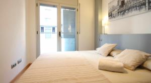 1 dormitorio con 1 cama grande y ventana grande en Mazi Apartments Downtown, en Mataró