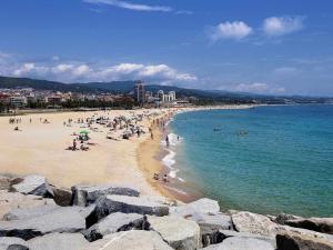 un grupo de personas en una playa cerca del agua en Mazi Apartments Downtown, en Mataró